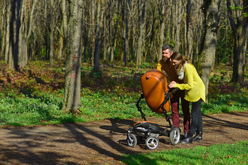 Babysitting services. Bearded man and pretty woman babysitting with baby pram in spring park. Child care service for working parents