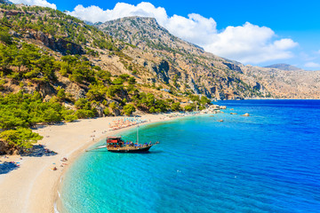 Sailing boat anchoring at beautiful Apella beach on Karpathos island, Greece - obrazy, fototapety, plakaty