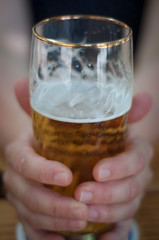 hand holding glass of beer
