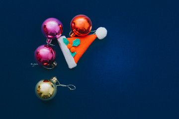 Christmas ornament balls and santa hat on grey background.