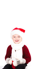 Merry Christmas and happy New year! Cute happy little boy holding red cup. Kid enjoy holiday santa hat. Portrait kid on light background isolated. Happy Child with place for text