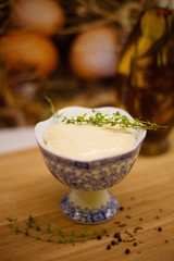 Homemade mayonnaise in a beautiful cup with a sprig of thyme