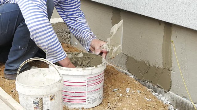 Worker use trowel plastering concrete at wall