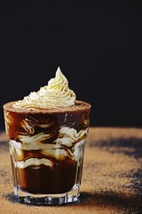 Mochaccino with whipped cream and chocolate isolated on dark