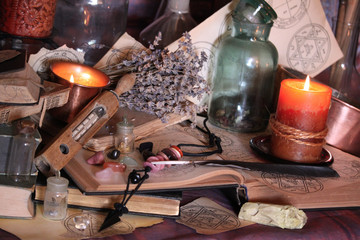 Antique Magic Book. Witchcraft Peacock feathers and candle background. Black candle Magic Ritual.