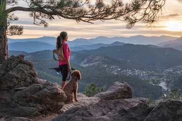 Foto op Canvas Een Spaanse vrouw wandelt met een hond, bij zonsondergang, in de Rocky Mountains bij Denver, Colorado, VS © Larry