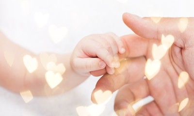New born baby hand holding kuman hand on white background
