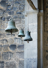 Fototapeta premium three church bells of small, medium and large size hanging in chains