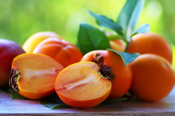 fresh ripe persimmons isolated on green background