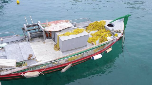 Fishing boat stands on the pier in clear water. Fishing boat. 4K
