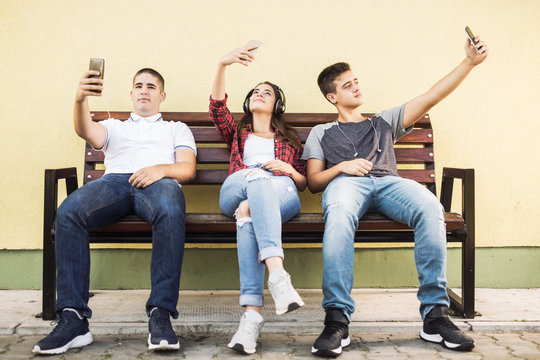 Three Teenagers Taking Selfies