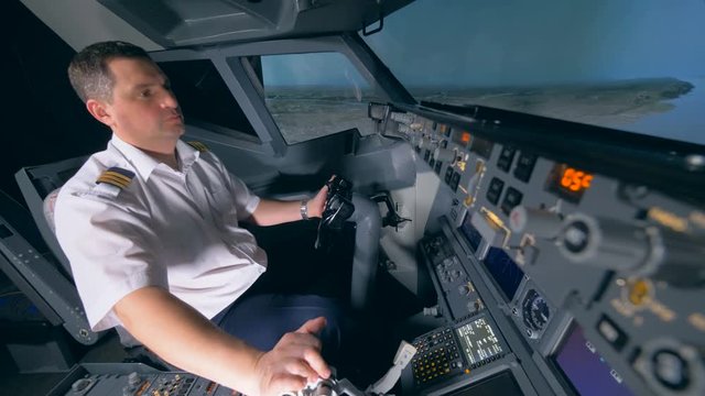 Professional pilot flies a plane simulator, close up.