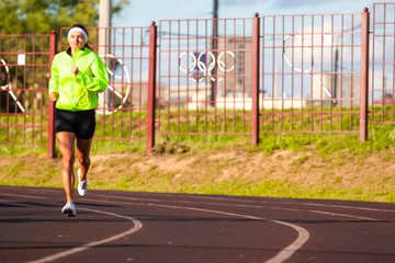 Fototapeta premium Jogging Concepts. Portrait of Professional Female Runner During Outdoor Training. Running on Track and Equipped in Summer Training Outfit While Running.