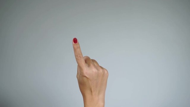 Closeup view of beautiful female hand with fresh red glossy sparkling gel polish manicure counting 1, 2, 3, 4. 5 using fingers. Hand of caucasian woman raised up isolated on light grey background. 4k