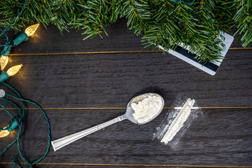 Drug use at Christmas during the holidays concept on wood background. Cocaine substance abuse problem