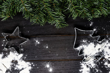 Christmas tree and star cookie cutter on wood background with flour. Concept for holiday baking and...