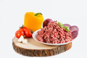 fresh raw minced beef in a plate close up on a rustic wooden cutting board