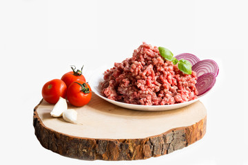 fresh raw minced beef in a plate close up on a rustic wooden cutting board