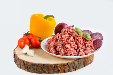 fresh raw minced beef in a plate close up on a rustic wooden cutting board