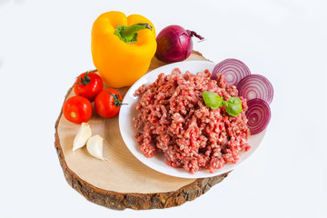 fresh raw minced beef in a plate close up on a rustic wooden cutting board