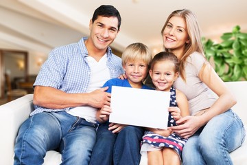 Young  family at home smiling at camera