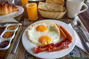 Delicious English Breakfast with fried eggs, sausages, bacon, jam and more