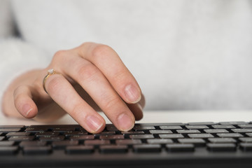 Fototapeta premium Closeup of business woman's hand typing on computer keyboard. Woman's hands touching notebook (laptop) keys during work. PC mouse in a hand. Woman's hand with computer mouse. Working at office.