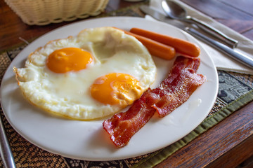 Delicious English Breakfast with fried eggs, sausages, bacon, jam and more
