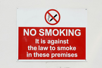 No smoking sign on white external wall of building
