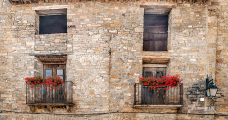 Fototapeta na wymiar Facade of ancient house decorated with flowers