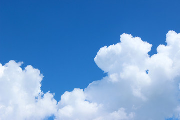 Clear blue sky with puffy clouds