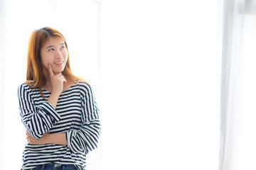 Beautiful portrait young asian woman confident thinking with curtain background, girl standing expression serious or doubts with idea, lifestyle concept.