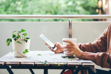 Female drinks hot beverage and chats, reads social network, puts likes on cell phone after hard...