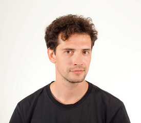 Fototapeta premium Close-up portrait of young pleased man in black T-shirt