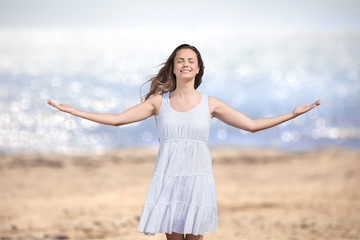 Happy woman with arms open on natural background