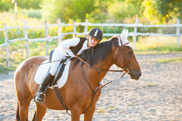 Girl equestrian rider riding a beautiful horse  in the rays of the setting sun. Horse theme