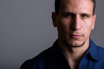 Obraz premium Close up of young muscular Persian man against gray background