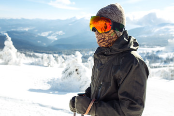 Nice man skiing in the mountains. Good skiing in the snowy mountains,  Winter is coming, first snowfall. Ski resort season is open. Ski equipment, trail. 