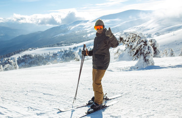 Nice man skiing in the mountains. Good skiing in the snowy mountains,  Winter is coming, first snowfall. Ski resort season is open. Ski equipment, trail. 