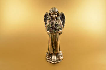 Angel statue stock images. Angel on a gold background. Angel figurine on a golden background with...