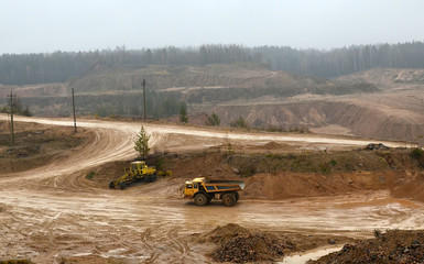 Top view panorama of deep kaolin strip mine with dumper trucks and cranes. Quarry for the extraction of minerals. The work of construction equipment in the mining industry