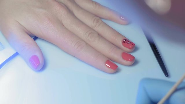 Close-up, Master Manicure Decorates the Nail on the Girl's Hand with Artificial Faceted Pebbles