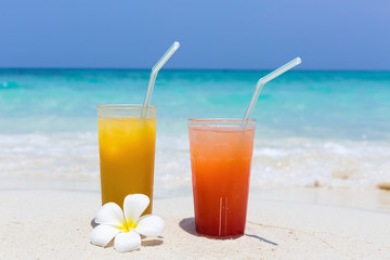 Cocktails in glass on white sandy beach