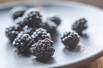 large juicy blackberry berries on a ceramic plate