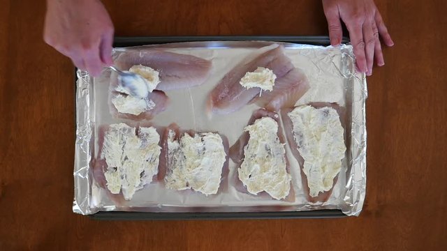 Chef prepares pollock for oven, close up