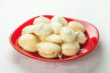 red plate with meringues on a white background