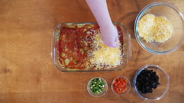 Close up, adding shredded cheese to 9 layer dip