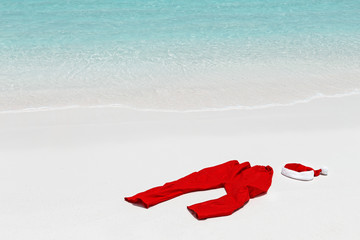 Santa Claus costume lying on sand,