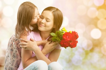 Portrait of happy mother and daughter holding  flowers