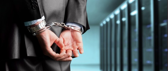 Cropped image of male hands in handcuffs behind his back
